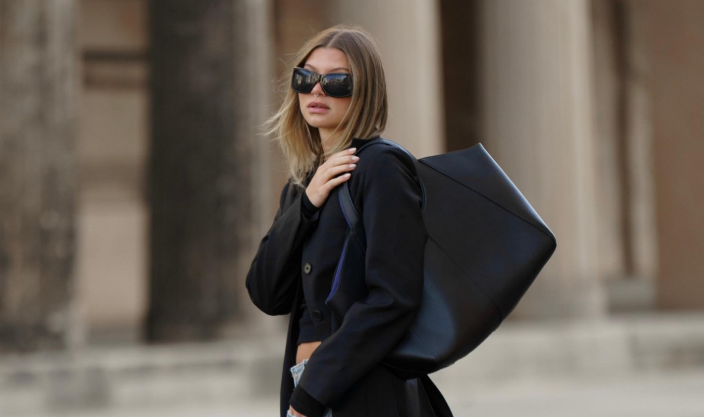 Editorial — navy blazer and structured black tote against stone columns