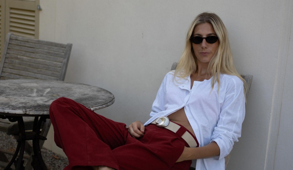 Editorial — open white shirt, burgundy wide-leg trouser, and shell belt