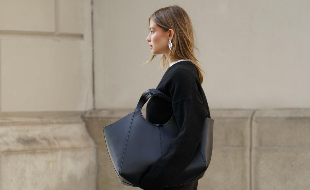 Editorial — black sweater and geometric leather tote in profile